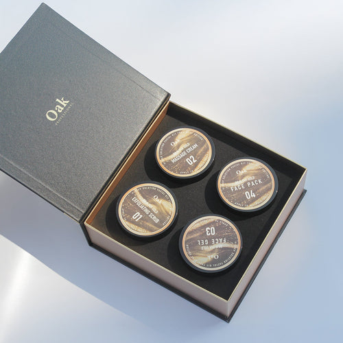 Set of four round metallic items in a 'Oak' branded box on a light blue background
