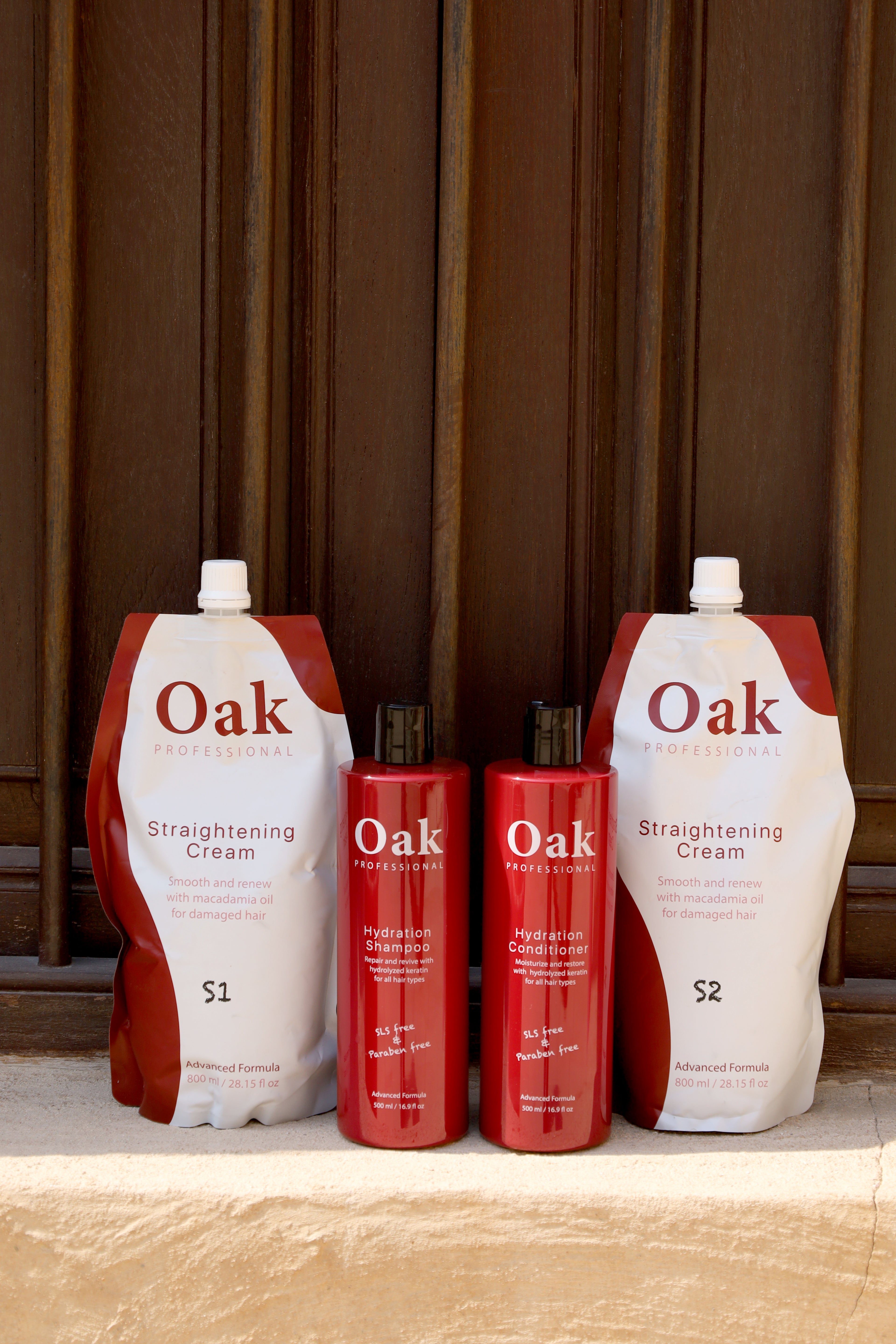Oak hair care products including Straightening Cream and Shampoo on a wooden surface with a brown curtain background.