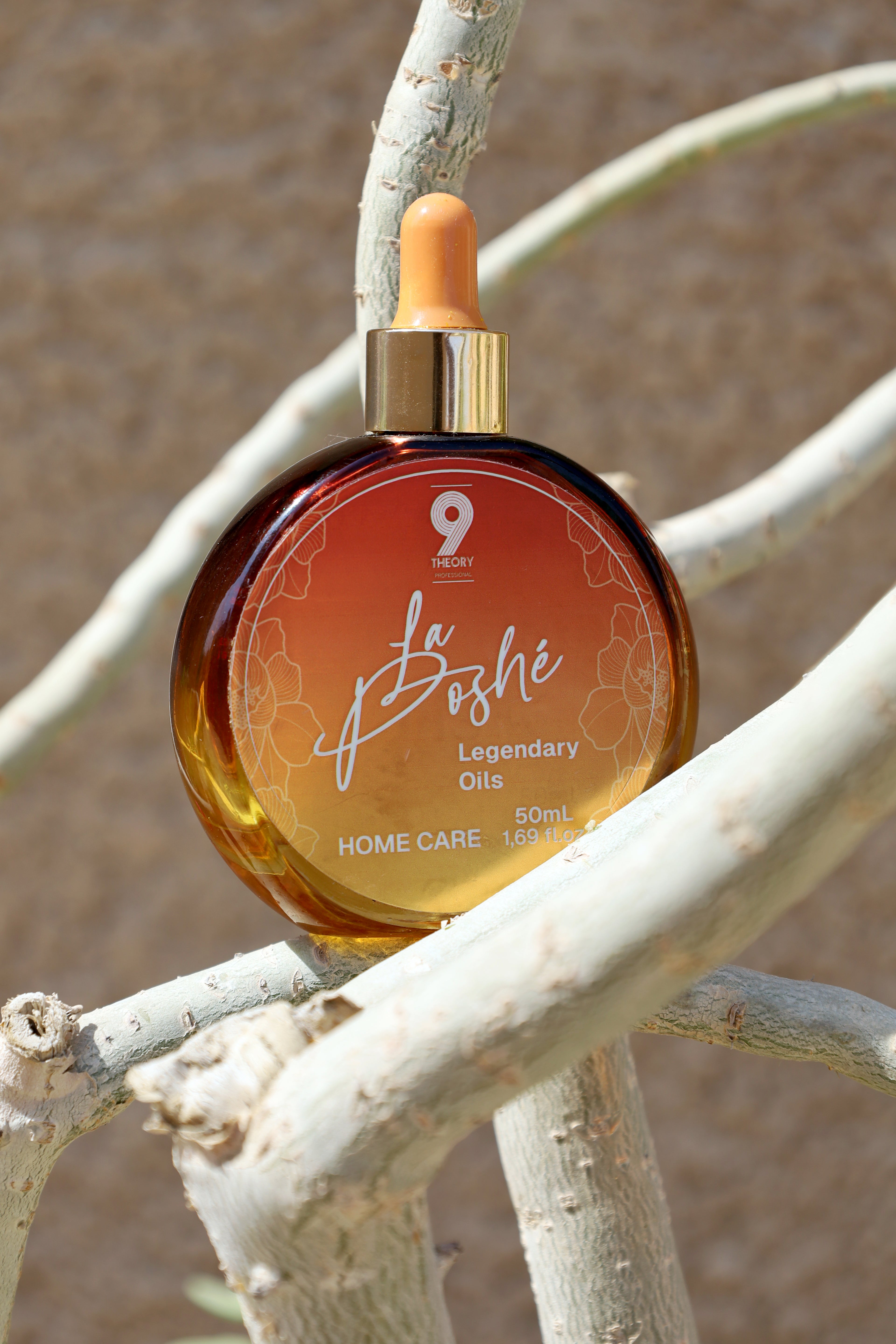 La Bohé oil bottle on a branch with a neutral background